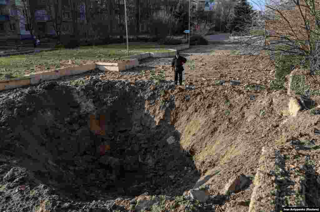 Lokalni stanovnik gleda u krater od ruskog raketnog udara u Hersonu, 5. decembra.