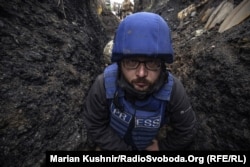 Serhiy Nuzhnenko, fotoreporter la Serviciul ucrainean al RFE/RL, într-o tranșee lângă satul Pivdenne, regiunea Donețk din estul Ucrainei, în aprilie 2022. El și jurnalistul RFE/RL Marian Kușnir, au fost forțați să se ascundă într-un șanț din cauza tirurilor de mortiere rusești.