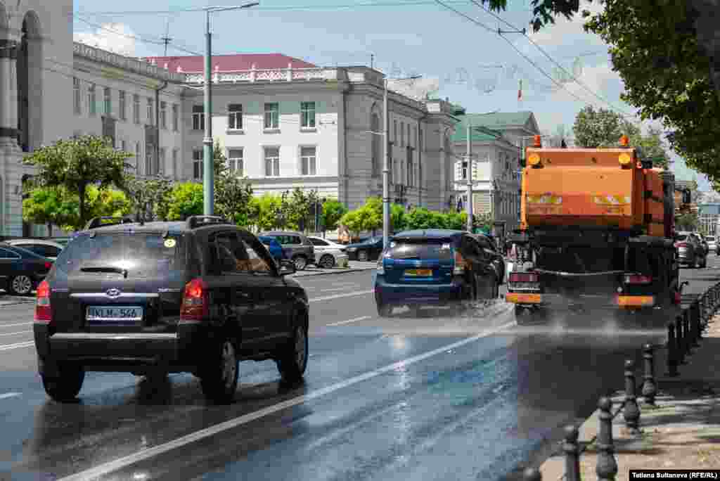 Autospecialele regiei „Exdrupo” stropesc străzile cu apă pentru a răci asfaltul.