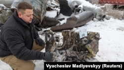 Un anchetator ucrainean arată părți ale unei rachete despre care autoritățile de la Kiev cred că a fost fabricată în Coreea de Nord și a fost utilizată într-un atac la Harkov, în ianuarie 2024. 