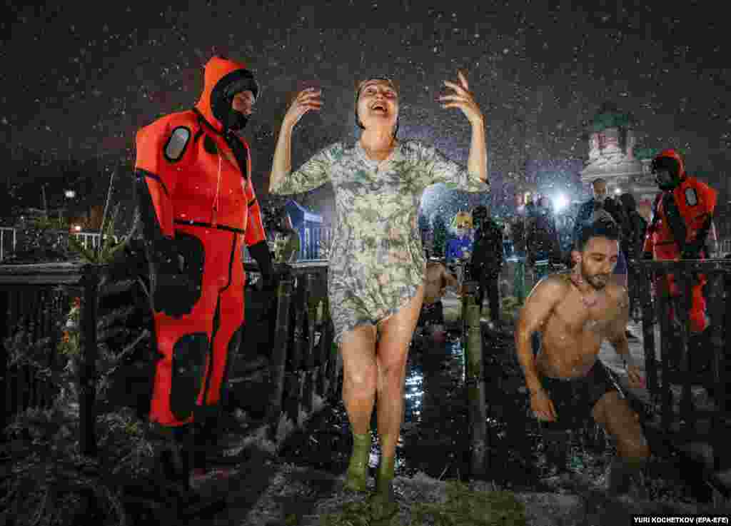 De Bobotează, credincioșii fac baie în apa rece ca gheața, la Moscova, în seara zilei de 18 ianuarie. Mulți creștini ortodocși din întreaga lume au marcat Boboteaza pe rit vechi, una dintre cele mai mari trei sărbători ale credinței creștine. (foto EPA-EFE/Yuri Kochetkov)