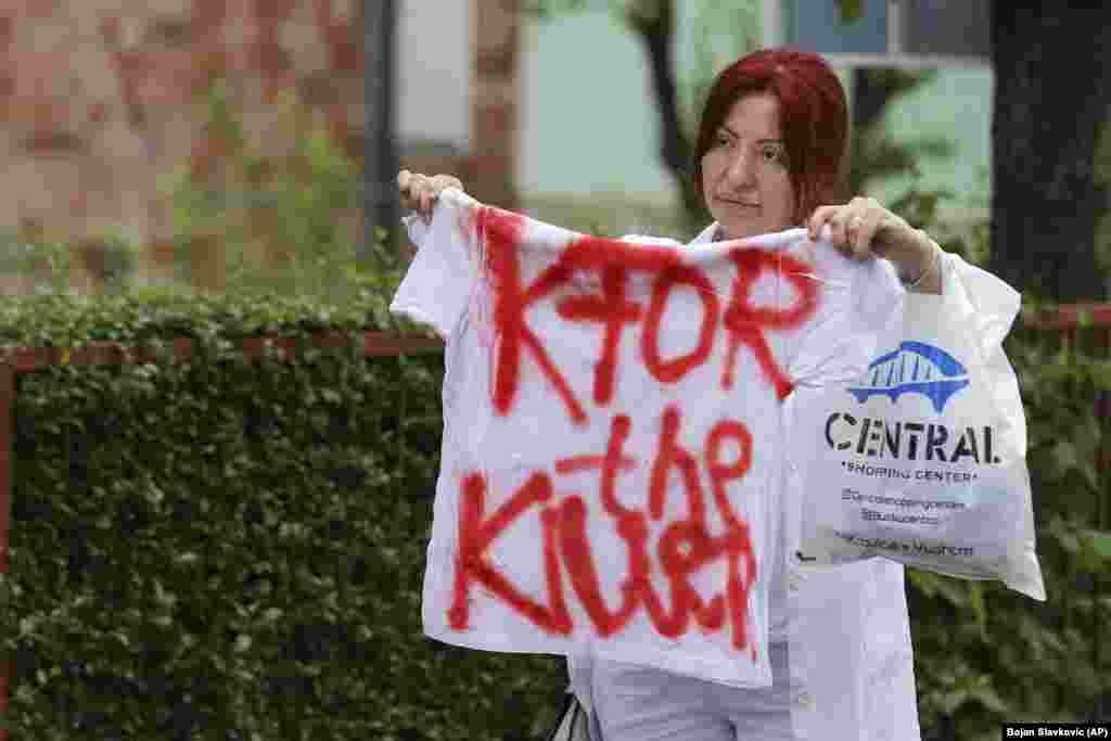 Žena drži majicu sa natpisom "KFOR, ubica", na protestu ispred zgrade Opštine u mestu Zvečan, na severu Kosova, u sredu, 31. maja 2023. godine.
