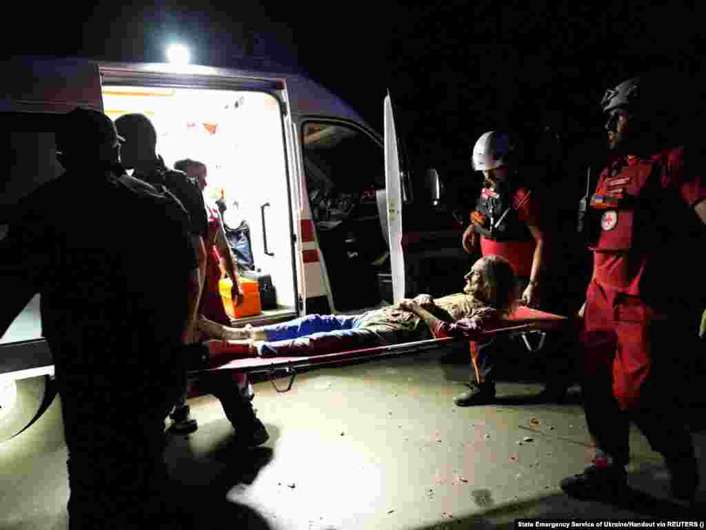 Paramedicii transportă o femeie rănită în timpul atacului cu rachete rusești din Nikolaev. "Rușii au lovit centrul orașului. Un garaj și o clădire rezidențială cu trei etaje au luat foc.... În total, 18 persoane au fost rănite. Nouă dintre ele au fost spitalizate, inclusiv cinci copii, în timp ce două persoane au fost salvate de sub dărâmături. Este un miracol că am reușit să le salvăm", a declarat guvernatorul regional Vitali Kim.