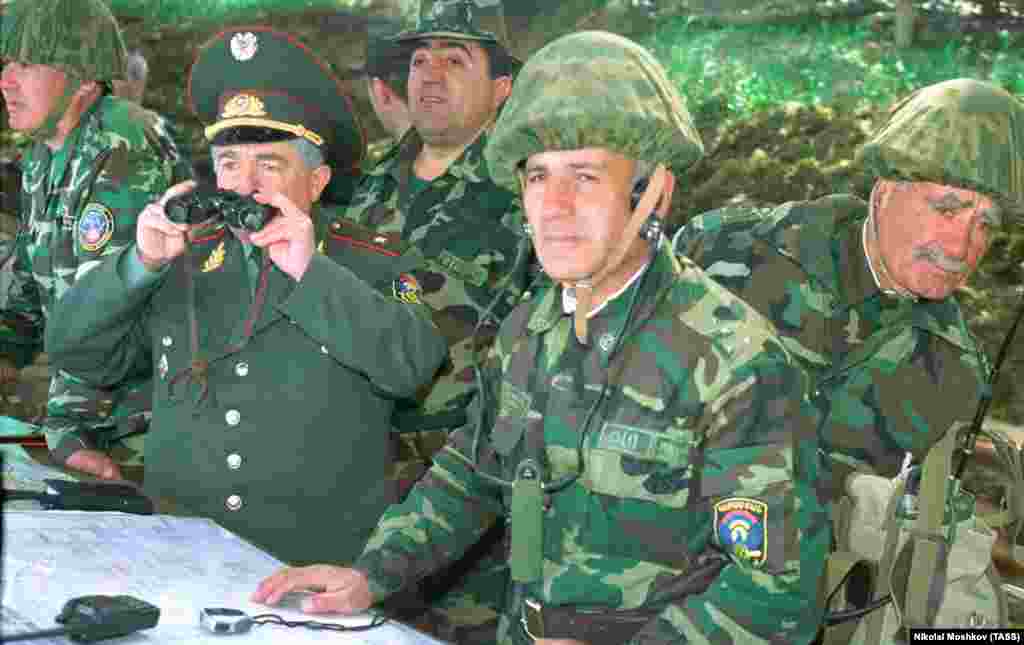 Ofițeri armeni supraveghează un exercițiu militar OTSC în regiunea Ninji Novgorod din Rusia, în 2002. OTSC este o alianță militară formată din mai multe foste republici sovietice care este văzută pe larg ca o variantă rusească a NATO. Cel puțin în documente, alianța este unită de clauza „un atac asupra unuia este un atac asupra tuturor”, prevăzută și la articolul 5 din Tratatul NATO. 