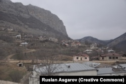 Găuri de gloanțe observate pe fațada clădirii școlii din Dasalti/Karintak (în prim-plan) în decembrie 2021.