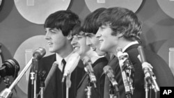 The Beatles se adresează jurnaliștilor în sala de presă a Aeroportului Internațional Kennedy la sosirea lor, pe 7 februarie 1964, la New York.