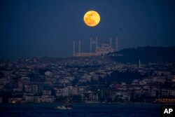 Hëna e plotë mbi minaret e xhamisë Camlica në Stamboll.