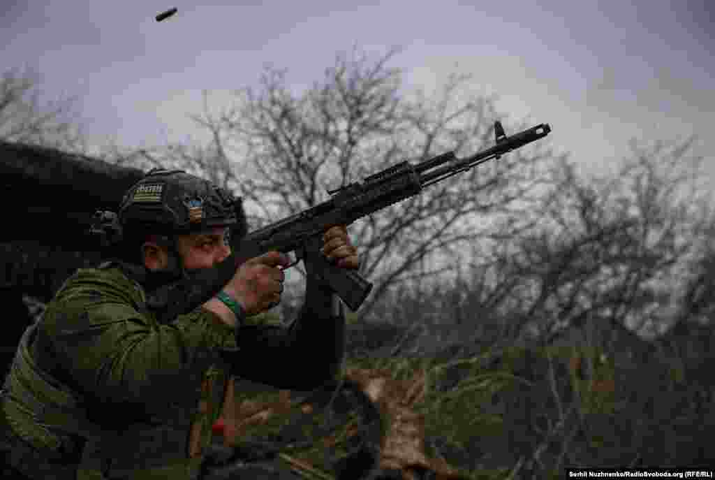 Украинский военнослужащий из 93-й механизированной бригады стреляет из автомата АК-74 по российским позициям возле Бахмута 6 марта. Несмотря на нехватку артиллерии и техники, украинские войска пытаются замедлить продвижение российских войск на фронте протяжённостью почти 1200 километров &nbsp;