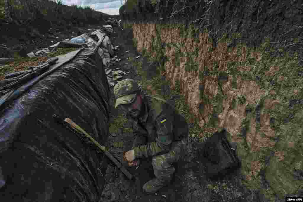 Un soldat ucrainean în tranșee, pe linia frontului de lângă Bahmut,pe 22 mai. Cu două zile mai înainte, șeful grupului de mercenari Wagner din Rusia, Evgheni Prigojin, a afirmat că trupele sale au preluat controlul asupra orașului.