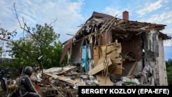 Українські рятувальники працюють на місці удару бомби на приватну будівлю в Харкові, 10 червня 2024 року