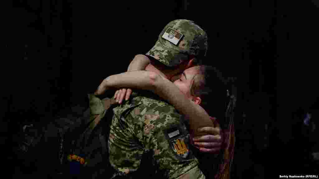 Un soldat ucrainean își îmbrățișează partenera la sfârșitul unui scurt concediu de pe front, la gara Kramatorsk, din estul Ucrainei. Fotojurnalistul RFE/RLSerhi Nujnenko, autorul acestei serii de fotografii, este unul din puținii reporteri acreditați pe linia frontului. 