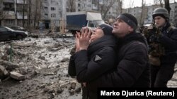 O femeie reacționând la salvarea fratelui ei dintr-un bloc de apartamente grav avariat de un atac cu rachete în Pokrovsk, în regiunea ucraineană Donețk, pe 15 februarie