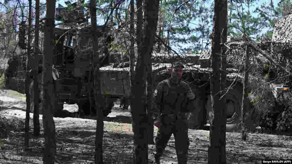 A 45. tüzérdandár katonái egy erdőben várják a parancsot. Háttérben egy Archer önjáró löveg, amelyet a svéd BAE Systems Bofors fejleszt és gyárt. A&nbsp;szerkezet a legjobb automata ágyúnak számít a világon, többek között azért, mert 7,5 másodpercenként képes leadni egy lövést