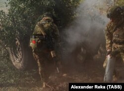 Руски војник со мало советско знаме на опремата пука со хаубица во областа Луганск во Украина на 4 октомври