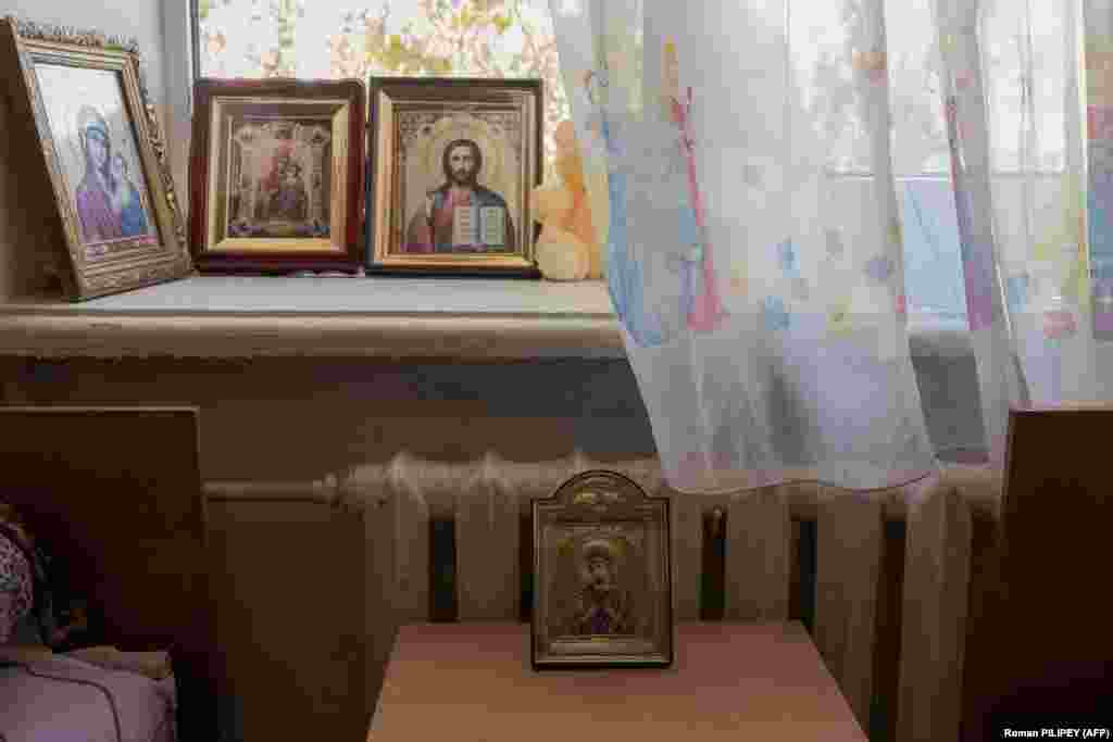 Icoanele religioase ale unei familii împodobesc camera în care locuiesc în centrul de primire a refugiaților. În vreme ce unele familii au părăsit orașul Herson, altele au preferat să rămână. &nbsp;