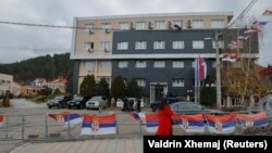 Një grua duke ecur para ndërtesës komunale në komunën e Leposaviqit, në veri të Kosovës, më 8 dhjetor 2023.