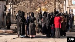 Studente afgane sunt oprite de personalul de securitate taliban în apropierea unei universități din Kabul, la 21 decembrie. 
