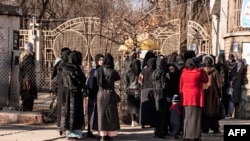 Fete afgane la porțile unei universități din Kabul la scurt timp după ce talibanii le-au interzis accesul.