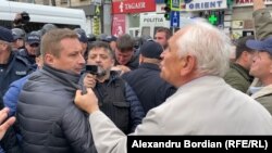 Politicianul pro-rus, Valerii Klimenko (dreapta), fondatorul partidului Ravnopravie devenit Partidul Șor, în altercații cu un membru în civil al forțelor de ordine, la un protest antiguvernamental la Chișinău, 30 octombrie, 2022