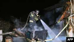 Një zjarrfikës ukrainas shuan një zjarr pas një sulmi me dronë rusë në Harkiv më 29 mars.