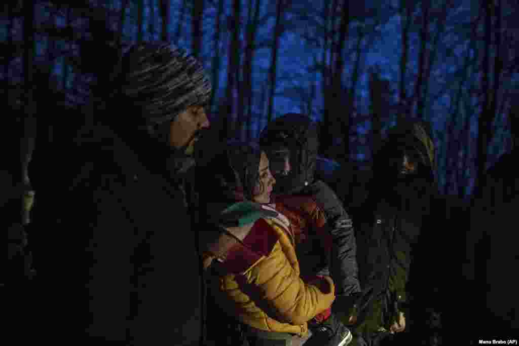 Migranti indian Suhil, 23-vjeçar, ndihmon Fatmën, për të mbajtur djalin e saj, derisa po kalonin malet midis Bosnjës dhe Kroacisë afër qytetit të Bihaq, në veriperëndim të Bosnjës. 