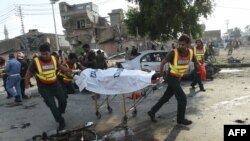 Rescue workers move the body of a victim at the site of an explosion in the eastern Pakistani city of Lahore on July 24.