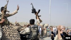FILE: Afghan civilians cheer their security forces after they killed militants during an attack at Kabul International Airport.