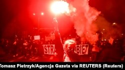 Fáklyát tart a kezében az abortuszt gyakorlatilag megtiltó alkotmánybírósági ítélet ellen tüntetők egyike a lengyelországi Wroclawban, 2020. október 26-án