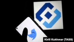 Twitter социалдык түйүнүн логотиби телефондун фонунда.