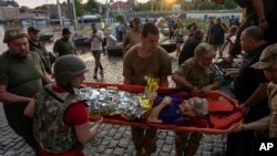 Voluntari evacuează o femeie dintr-un cartier inundat din Kherson, Ucraina, la 7 iunie. 