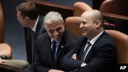 Premierul Israelului, Naftali Bennett (dreapta), și ministrul de Externe Yair Lapid (care va conduce guvernul până la alegerile din toamnă) înaintea votului de joi, 30 iunie, de dizolvarea a Knesset-ului, legislativul israelian. 