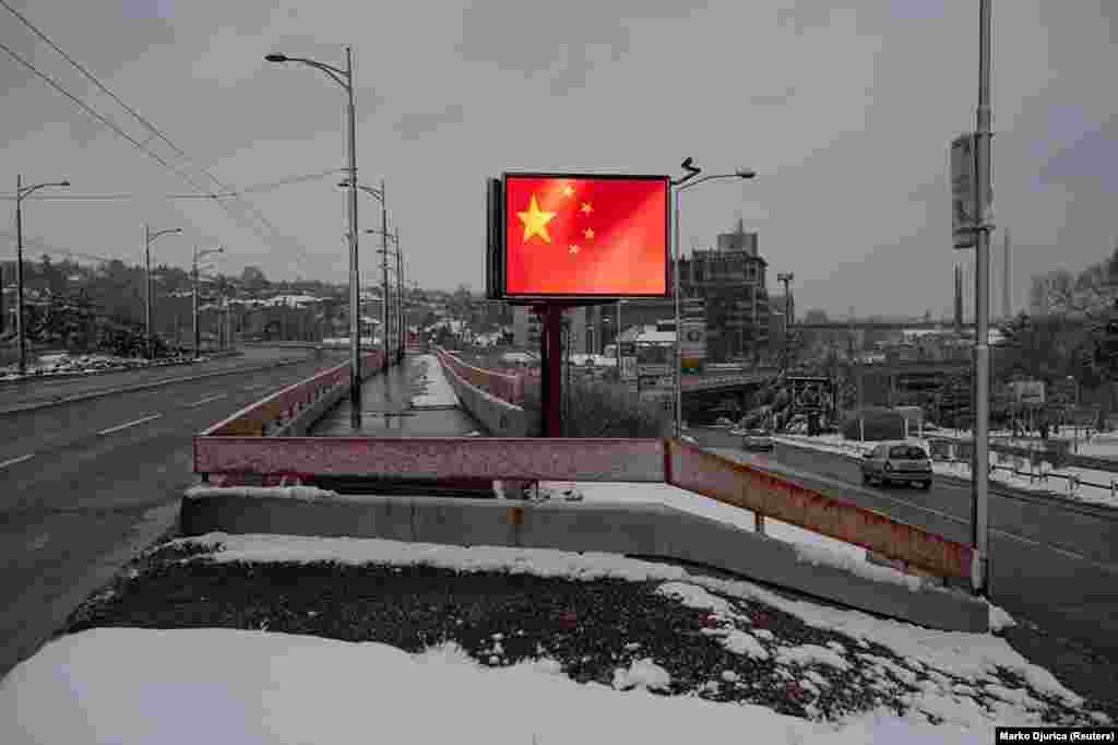 Развевающийся флаг Китая на огромном мониторе в столице Сербии, Белграде. Это — одно из нескольких прокитайских визуальных решений, появившихся в Сербии во время пандемии коронавируса.