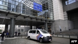 O mașină a poliției belgiene în fața Parlamentului European, la Bruxelles, la 29 mai 2024, când procurorii belgieni au făcut percheziții legate de presupuse încercări ale Rusiei de a corupe politicieni din UE pentru a-i promova interesele.