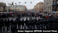 Russian law enforcement officers block a road as protesters march during a rally in support of jailed Russian opposition leader Alexei Navalny in St. Petersburg on January 23.
