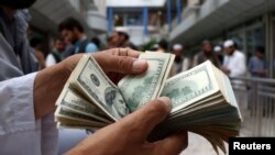 آرشیف - یک صراف در سرای شهزاده کابل بانک نوت های دالرش را شمار می‌کند