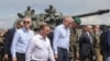 Secretarul general al NATO, Jens Stoltenberg (stânga), președintele Lituaniei, Gitanas Nauseda (dreapta), și ministrul german al apărării, Boris Pistorius (centru), vizitează tabăra de antrenament de la Pabrade, Lituania, 26 iunie 2023.