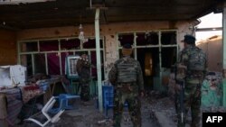 FILE: Afghan National Army soldiers inspect buildings after clashes with militants.