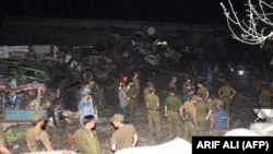 Pakistani security officials inspect the site of an explosion in Lahore on August 7.