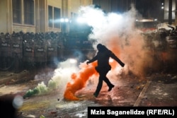 Maskirani policajac šutira dimnu bombu pored zgrade gruzijskog parlamenta u Tbilisiju 29. novembra tokom druge noći protesta koji su izbili nakon što je gruzijska vlada objavila obustavu pregovora o pristupanju EU.