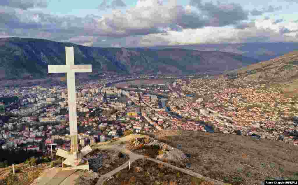 Vidikovac iznad Mostara kojim dominira krst visok 33 metra. Od kraja sukoba 1994. godine Mostar je podijeljen tako da uglavnom Hrvati žive na zapadnoj strani rijeke Neretve (lijeva strana fotografije), a Bošnjaci na istoku. 