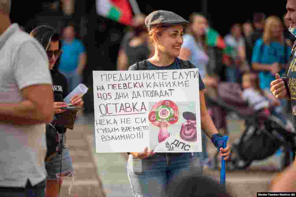 "Предишните слуги на Пеевски канихме 405 дни да подадат оставка. Нека не си губим времето ввзаимно", пише на пллакат, носен от жена на протеста в Пловдив. Препратката е към протестите срещу правителството на Пламен Орешарски, които започнаха след предлаганито на Делян Пеевски за шеф на ДАНС.