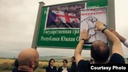 აქციის მონაწილეებმა ბანერებს ოკუპაციის გასაპროტესტებელი პლაკატები გადააკრეს