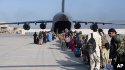 Oameni din Afganistan, evacuați cu un avion al Forțelor aeriene americane, în august 2021.