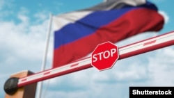 GENERIC – Barrier gate being closed with flag of Russia as a background. Russian restricted entry or certain ban. 3D rendering