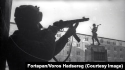 Un soldat sovietic fotografiat lângă un monument al unei unități militare maghiare.
