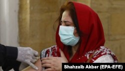 په کراچۍ کې يوې ښځې ته واکسين کېږي.