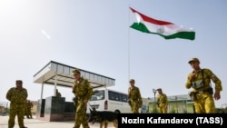 FILE: Tajik Servicemen of the Panj Border Service detachment walk at the Somon border outpost on the Tajik-Afghan border on August 14.