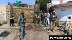 FILE: Afghan security force stand at the site of an attack in Jalalabad.