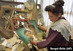 O fotografie făcută în iunie 2002 o arată pe Sabera Rahmani, directoarea Galeriei Naționale din Afganistan, cu una dintre cele peste 400 de picturi distruse de talibani în timpul celor șase ani de aflare a acestora la putere.
