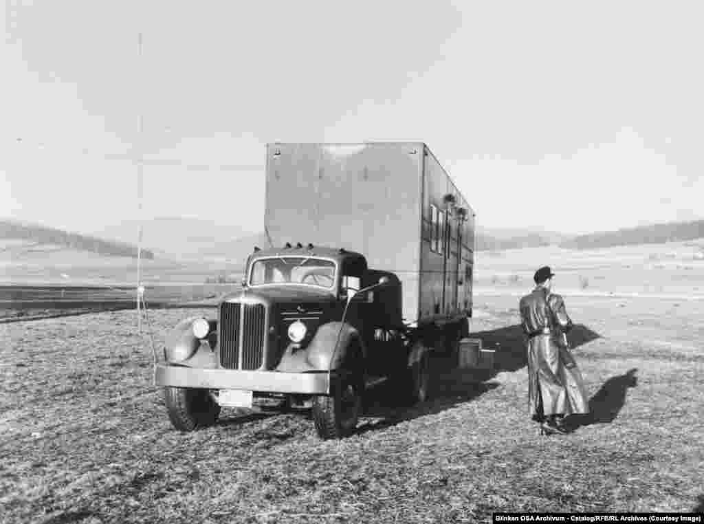 1955 йилда Ғарбий Германияда, Чехословакия билан чегара яқинида, қуролли аскар ўрта тўлқинли радиоузатувчи юк машинасини қўриқламоқда.Коммунистик давлатлар Озод Европа радиоси (RFE) ва Озодлик радиоси (RL) эшиттиришларини блоклашга ҳаракат қилганлари сабабли, RFE бунга жавобан ўнлаб мобил эшиттириш станцияларини жойлаштирган. Юқоридаги каби мобил узатгичлар Темир парда яқинида, яъни Шарқ ва Ғарб ўртасидаги чегарада фаолият юритиш имконига эга эди.